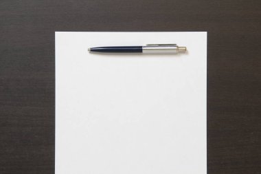 Koyu renkli ahşap arka planda beyaz kağıt şablonu. İş planı ve stratejisi kavramı. Metin ve tasarım için boş alanı olan stok fotoğrafı.