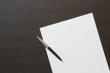 Koyu renkli ahşap arka planda beyaz kağıt şablonu. İş planı ve stratejisi kavramı. Metin ve tasarım için boş alanı olan stok fotoğrafı.