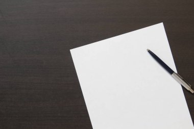 Koyu renkli ahşap arka planda beyaz kağıt şablonu. İş planı ve stratejisi kavramı. Metin ve tasarım için boş alanı olan stok fotoğrafı.