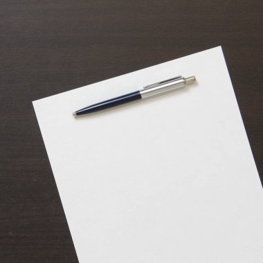 Koyu renkli ahşap arka planda beyaz kağıt şablonu. İş planı ve stratejisi kavramı. Metin ve tasarım için boş alanı olan stok fotoğrafı.