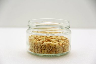 Beyaz arka planda iniltileri olan cam kavanoz, yan görüş. Sağlıklı beslenme, diyet, vejetaryen ürünler kavramı. Metin ve tasarım için boş alanı olan stok fotoğrafı.