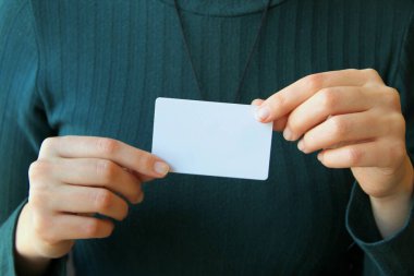 Kızın elinde beyaz bir dikdörtgen kart var. Tasarım için düzen ve modelleme, metin için yer, kopyalama alanı.