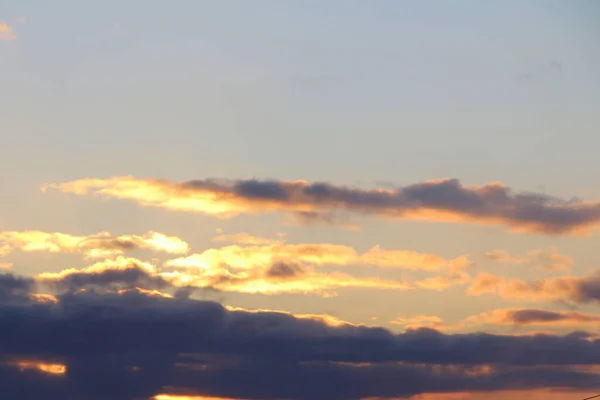 Nuvens no céu azul ao pôr-do-sol ou ao amanhecer iluminadas pelo sol. Lugar para texto e design — Fotografia de Stock