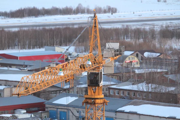 Bygga orange kran på bakgrunden av den urbana industrizonen, vinter stadsbild — Stockfoto