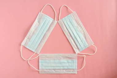 Pembe arka planda tek kullanımlık tıbbi maskeler. Coronovirüs Salgını Savunma Kavramı