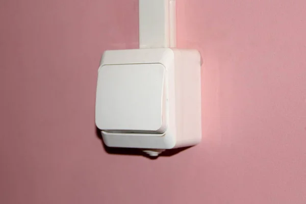 Interruptor elétrico de plástico branco em uma parede rosa — Fotografia de Stock
