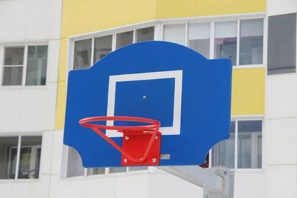 Červený basketbalový koš na modré desce na sportovním hřišti na ulici ve městě — Stock fotografie