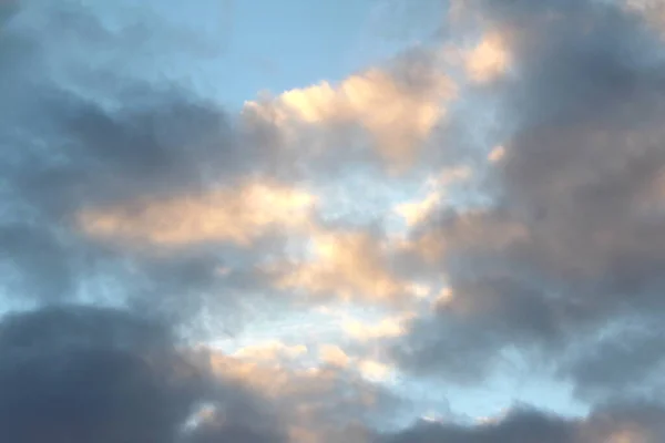 Moln i den blå himlen vid solnedgången eller gryningen bakgrundsbelyst av solen. Plats för text och design — Stockfoto