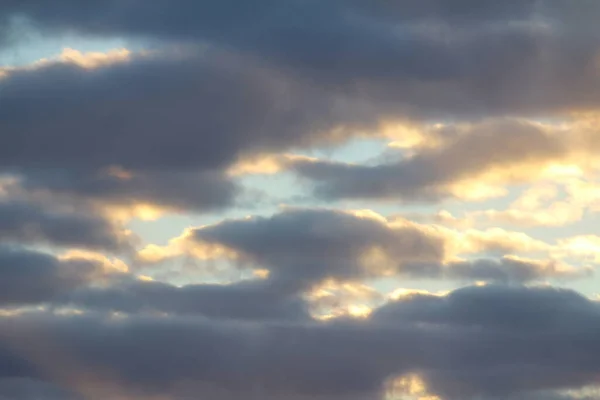 Nuvens no céu azul ao pôr-do-sol ou ao amanhecer iluminadas pelo sol. Lugar para texto e design — Fotografia de Stock