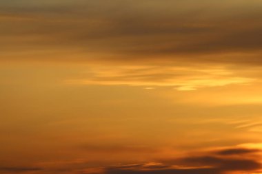 Ufkun altında güneş ve gün batımında veya şafakta güneşin aydınlattığı ateşli turuncu gökyüzünde bulutlar. Metin ve tasarım için yer