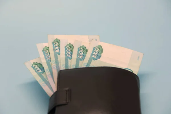 Lederen bruine portemonnee met Russisch geld dat eruit steekt in bankbiljetten. — Stockfoto