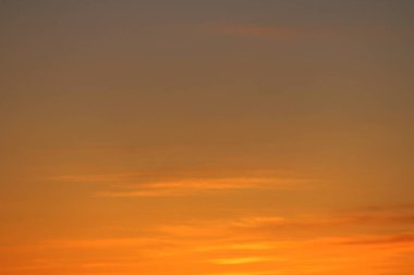 Ufkun altında güneş ve gün batımında veya şafakta güneşin aydınlattığı ateşli turuncu gökyüzünde bulutlar. Metin ve tasarım için yer