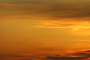 Ufkun altında güneş ve gün batımında veya şafakta güneşin aydınlattığı ateşli turuncu gökyüzünde bulutlar. Metin ve tasarım için yer