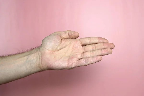 Main masculine à la peau claire montre un geste, main sur un fond rose clair — Photo