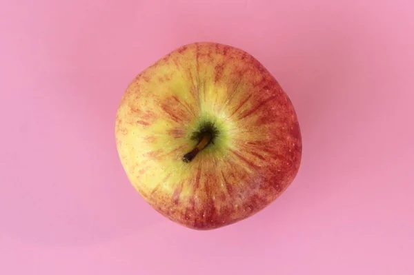 Manzana roja amarilla sobre fondo rosa. Jugosa fruta madura hermosa — Foto de Stock