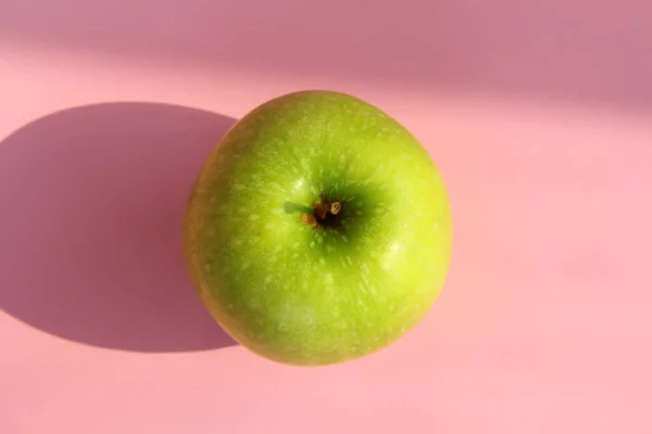 Green apple on a pink background. Juicy ripe beautiful fruit — Stock Photo, Image