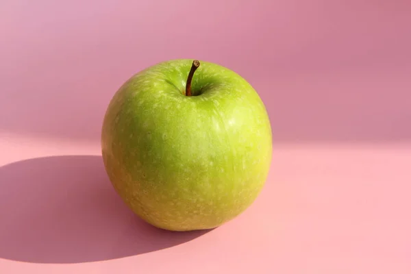 Πράσινο μήλο σε ροζ φόντο. Ζουμερά ώριμα όμορφα φρούτα — Φωτογραφία Αρχείου