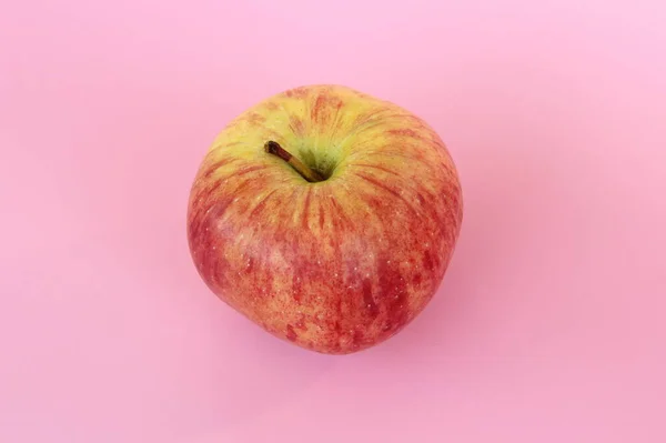 Maçã amarela vermelha em um fundo rosa. Fruta bonita madura suculenta — Fotografia de Stock