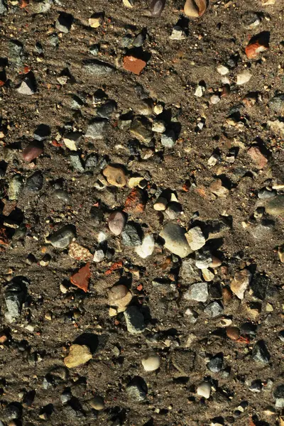 Маленькие камни и песок. Естественная текстура почвы. Берег водохранилища с пляжем и галькой — стоковое фото