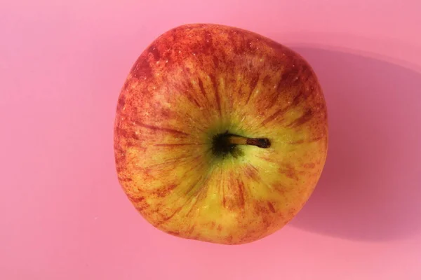 Red yellow apple on a pink background. Juicy ripe beautiful fruit — Stock Photo, Image