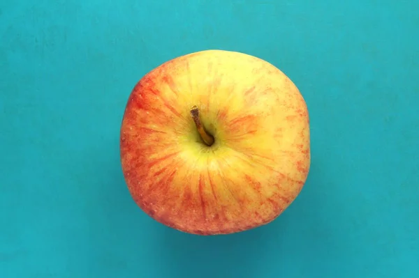 Maçã amarela vermelha sobre um fundo azul. Fruta bonita madura suculenta — Fotografia de Stock