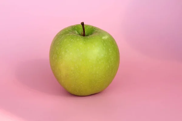 Green apple on a pink background. Juicy ripe beautiful fruit — Stock Photo, Image