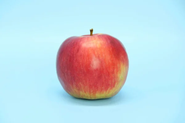 Κόκκινο κίτρινο μήλο σε μπλε φόντο. Ζουμερά ώριμα όμορφα φρούτα — Φωτογραφία Αρχείου