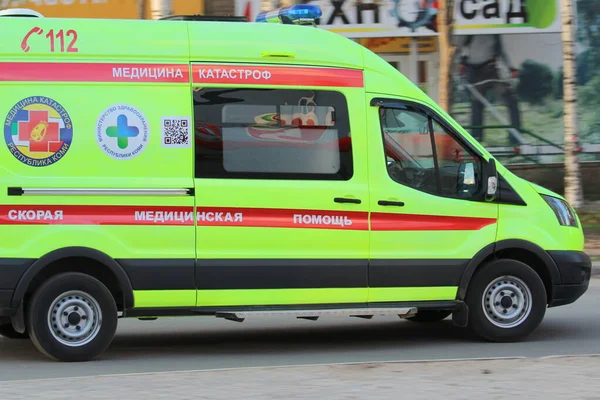 14-05-2020. Rusko, Syktyvkar. Bílá sanitka s červeným pruhem s modrými blikajícími světly na městské ulici v Rusku — Stock fotografie