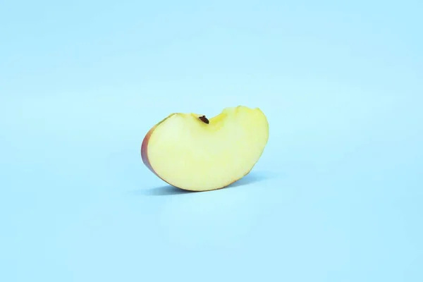 Slice a juicy fresh apple on a blue background. Delicious sliced fruit — Stock Photo, Image