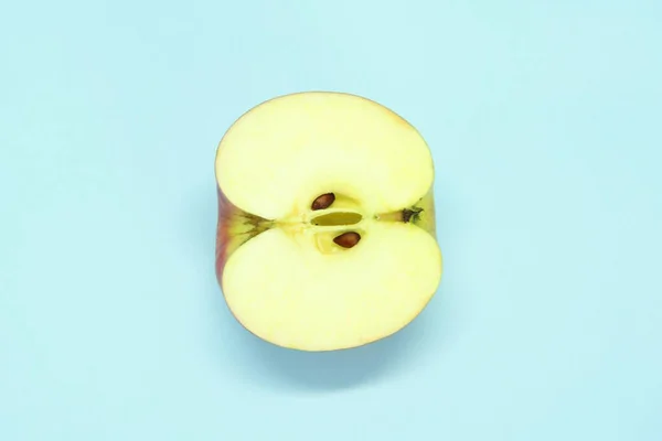 Μισό ζουμερό φρέσκο μήλο σε μπλε φόντο. Λαχταριστά φρούτα — Φωτογραφία Αρχείου