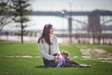 Güzel bir kız elinde bir buket bahar çiçeğiyle gezinti güvertesinde yürüyor, bir buket sümbül.