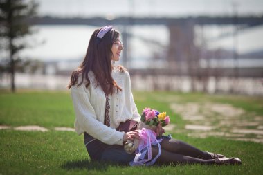 Güzel bir kız elinde bir buket bahar çiçeğiyle gezinti güvertesinde yürüyor, bir buket sümbül.