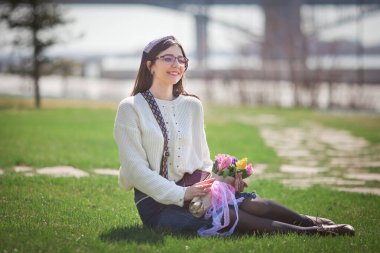 Güzel bir kız elinde bir buket bahar çiçeğiyle gezinti güvertesinde yürüyor, bir buket sümbül.