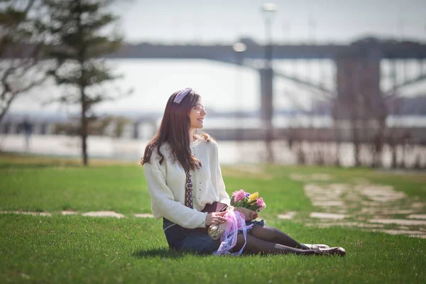 Güzel bir kız elinde bir buket bahar çiçeğiyle gezinti güvertesinde yürüyor, bir buket sümbül.