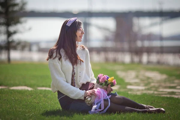 Güzel bir kız elinde bir buket bahar çiçeğiyle gezinti güvertesinde yürüyor, bir buket sümbül.