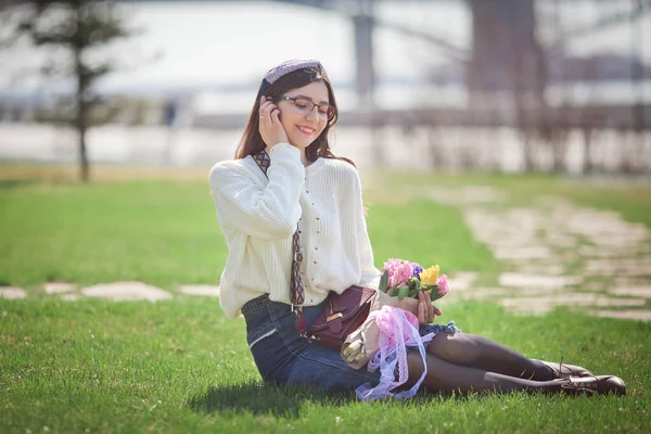 Güzel bir kız elinde bir buket bahar çiçeğiyle gezinti güvertesinde yürüyor, bir buket sümbül.