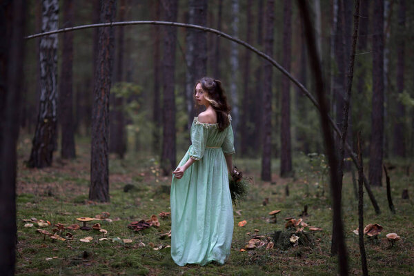сказка о фее в волшебном лесу, красивая девушка в зеленом платье гуляет по лесу с букетом, грибы в букете
