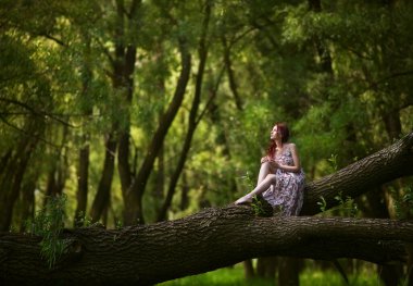 Kızıl saçlı kız, ormanda yürür. Yaz fotoğraf çekimi