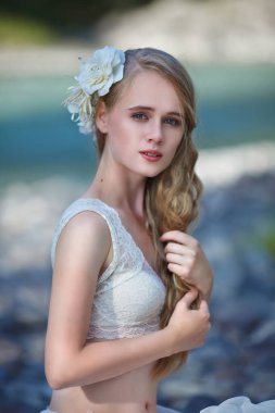 Deniz Kızının Hikayesi. Nymph Nehri 'nin Hikayesi. Beyaz elbiseli bir kız nehir kenarındaki kayalık bir sahilde duruyor. Altai 'de fotoğraf çekimi.