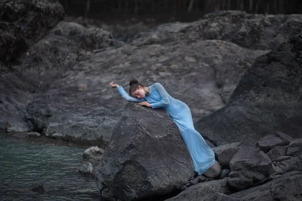 青いドレスの少女が川の近くの岩場の海岸に立っている 川のそばの夜 アルタイでの写真撮影 — ストック写真