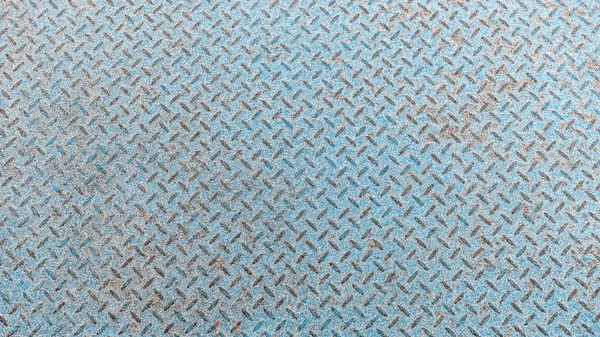 Metal coating pattern used as a floor. Painted in blue paint. From everyday life, the paint was wiped off making a beautiful background that can be used in advertising or design