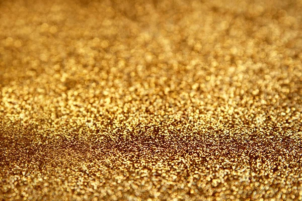 Gold glitter texture sparkling paper background. Abstract twinkled golden glittering background  with bokeh, defocused lights for Christmas holiday, banner, wedding invitation and greeting cards.