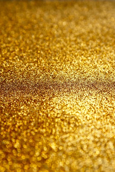 Gold glitter texture sparkling paper background. Abstract twinkled golden glittering background  with bokeh, defocused lights for Christmas holiday, banner, wedding invitation and greeting cards.