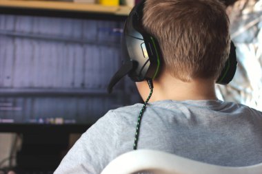 Z jenerasyonu konsepti. Kulaklık takmış bilgisayar oyunları oynayan sarışın gencin arka plan görüntüsü.