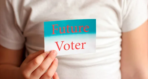 女の子の手に将来の有権者のサイン。投票や選択の概念を作る. — ストック写真