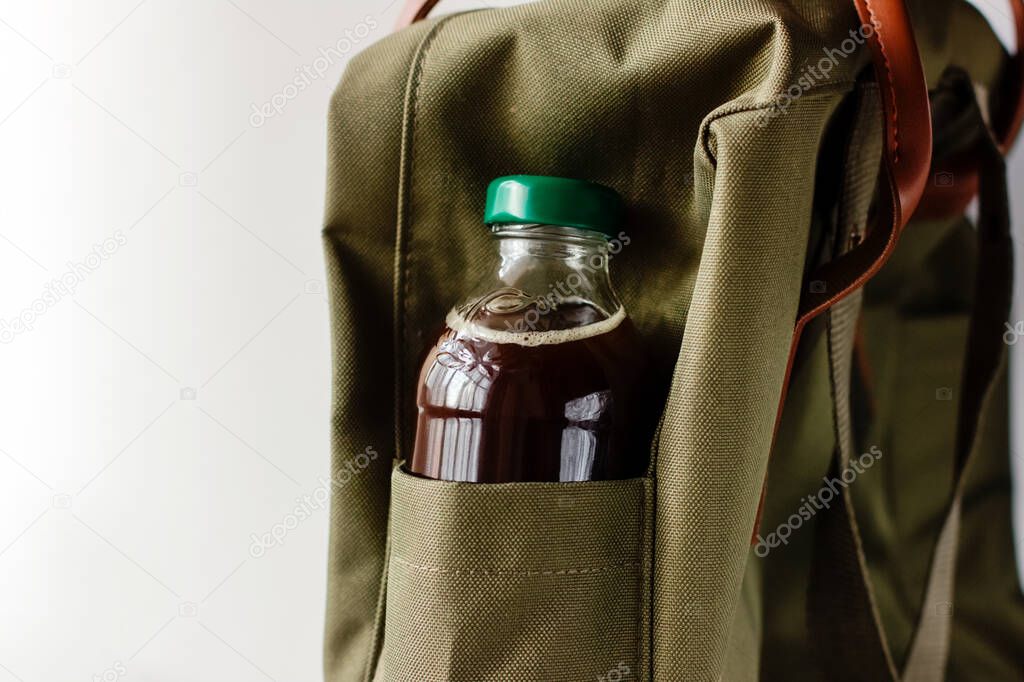 Cold brew coffee to go. Cold drink in a bottle in backpack pocket.