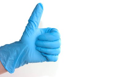 Başparmak yukarı. İşaret simgesi gibi. El lateks mavi eldiven işaret gibi görünüyor..