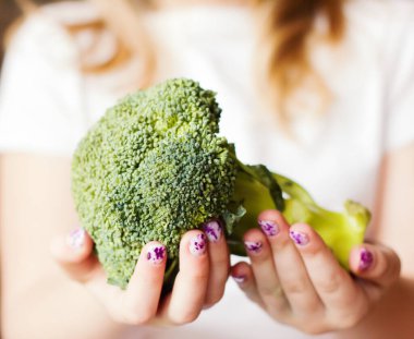 Sağlıklı yeşil organik çiğ brokoli. Brokoli çocuğun elinde. Çocuklar sağlıklı beslenme kavramı.