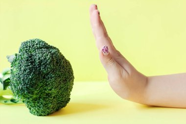 Sağlıklı yeşil organik çiğ brokoli. Brokoli yemeyi reddeden bir çocuk. Çocuklar sağlıklı beslenme kavramı.