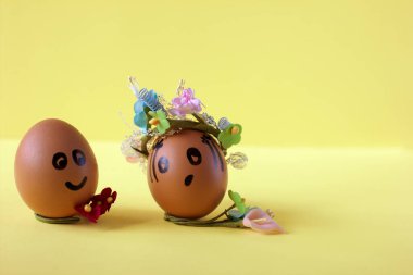 Komik boyalı yüzü ve tatlı çiçek çelengi olan doğal paskalya yumurtaları. Yaratıcı tatil tasarımı için komik gülümseyen karakterler.